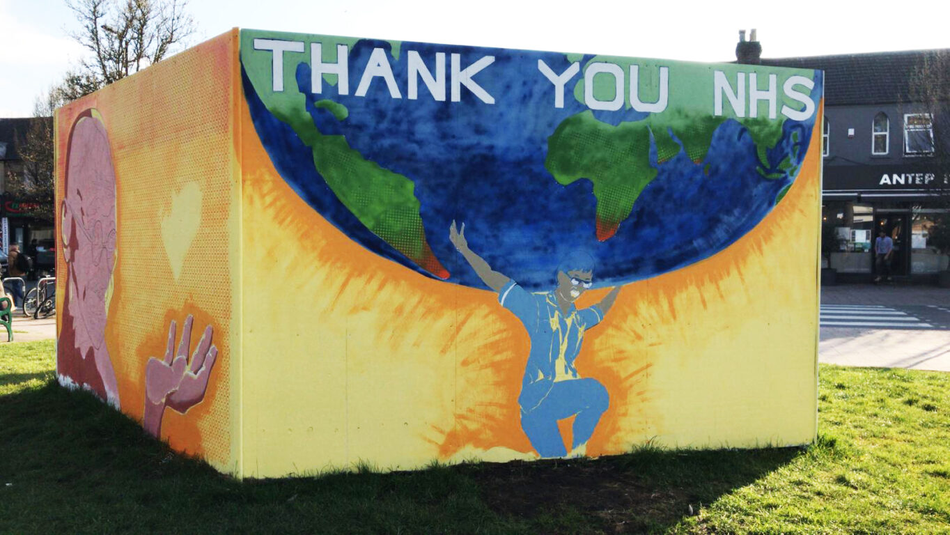 Tommy Watkin's Thank You NHS Mural. Bight yellow street art on park wall featuring NHS workers and Mahatma Gandhi.
