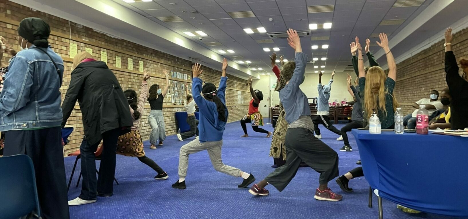 Group of adults and children learning a dance