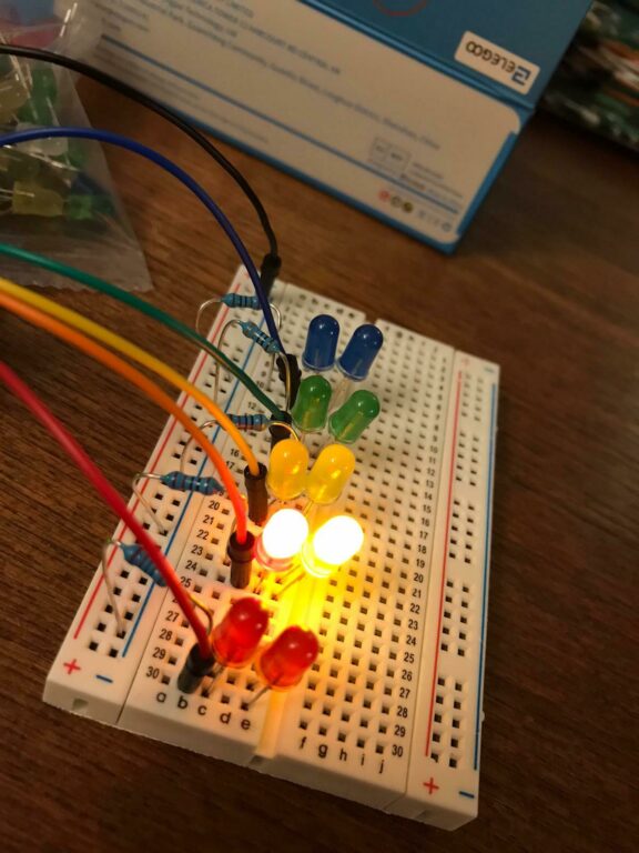 Set of multi-coloured wires attached to lit up coding device.