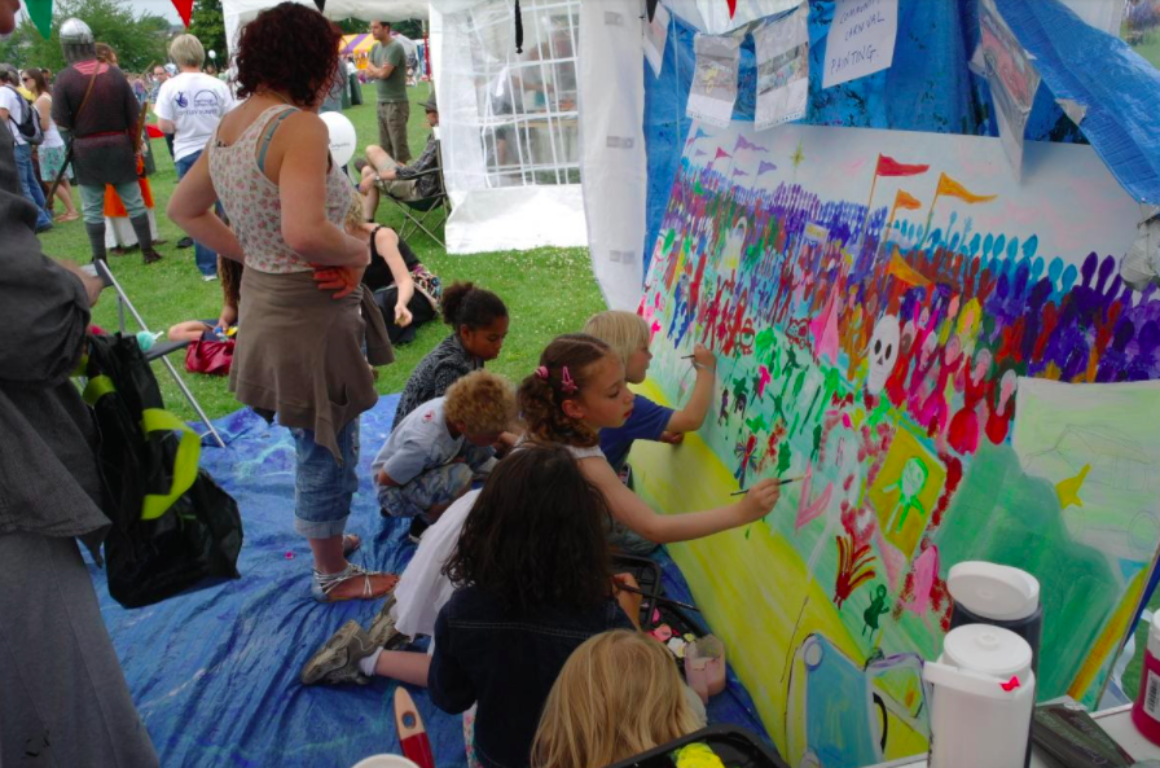 Children painting mural in tent.