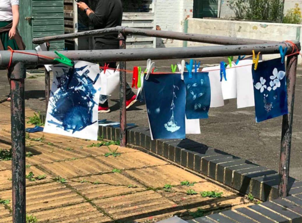 Cyanotypes drying outside, hung up on a string.
