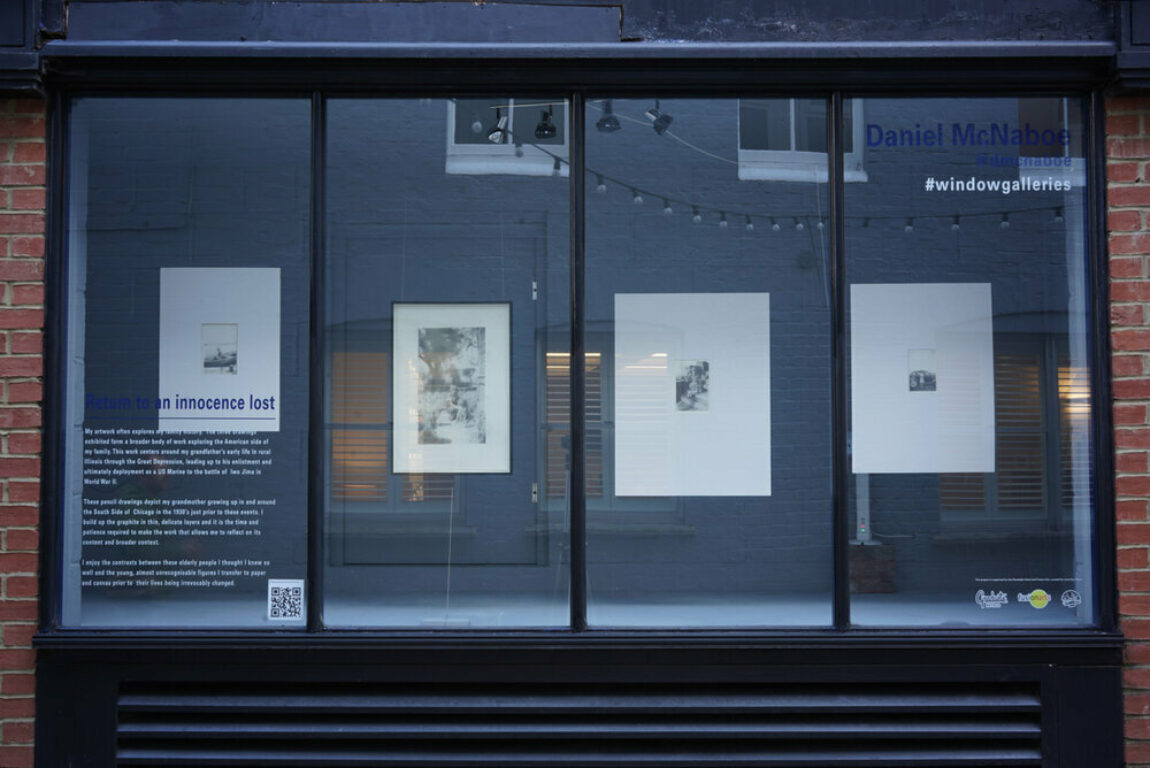Front of exhibition space seen from the street view with four works hung in the windows.