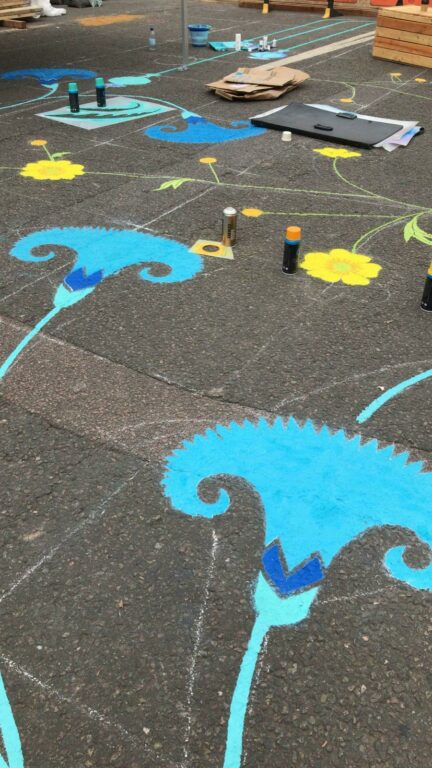 Close up of floral street painting of blue flowers.