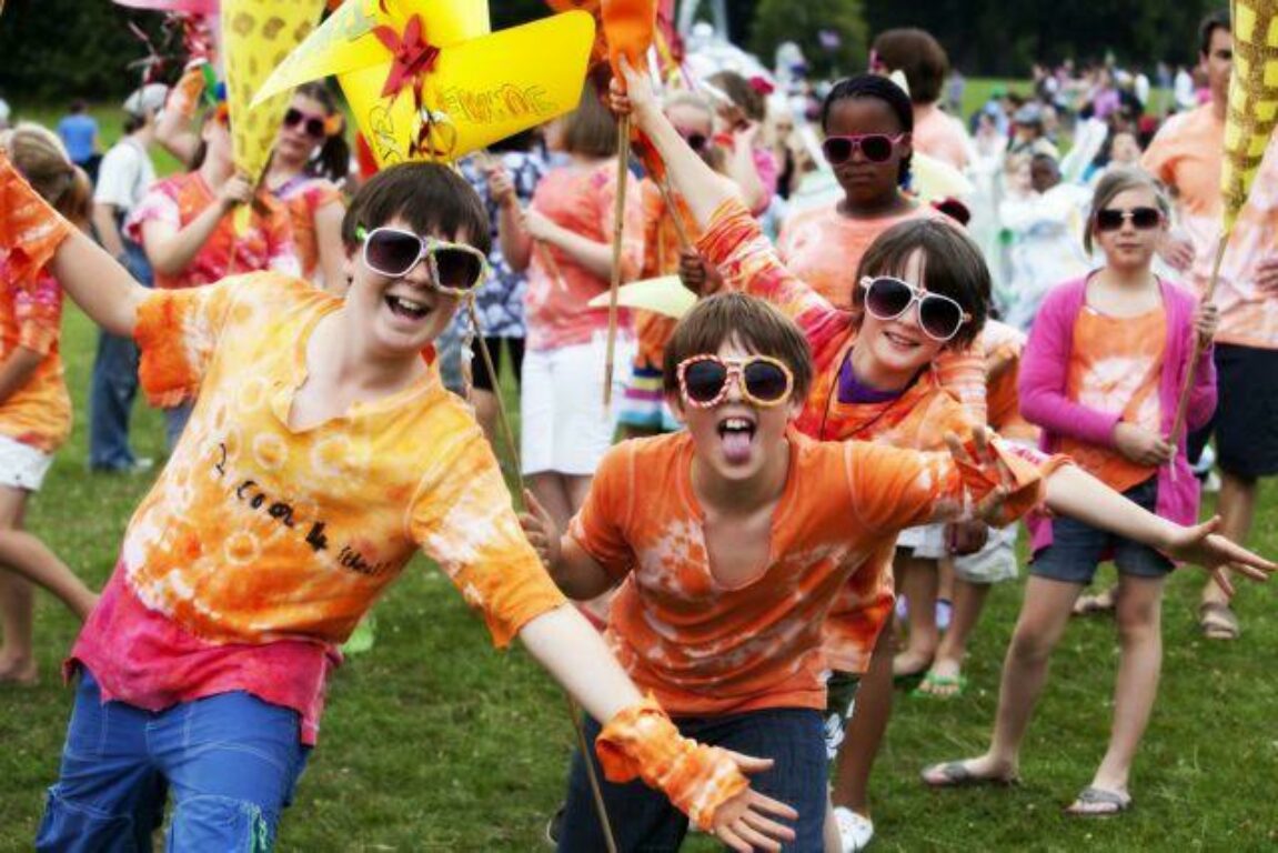 Young people dressed in orange tie dye with sunglasses