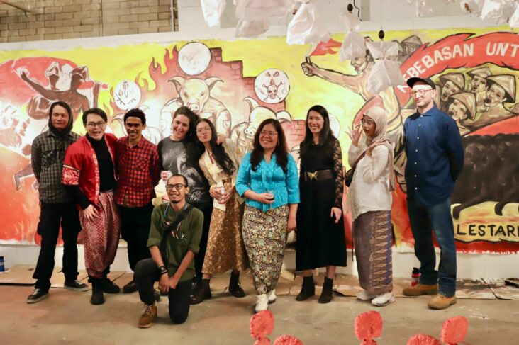 Soboman and Fusion team members posing in front of the mural